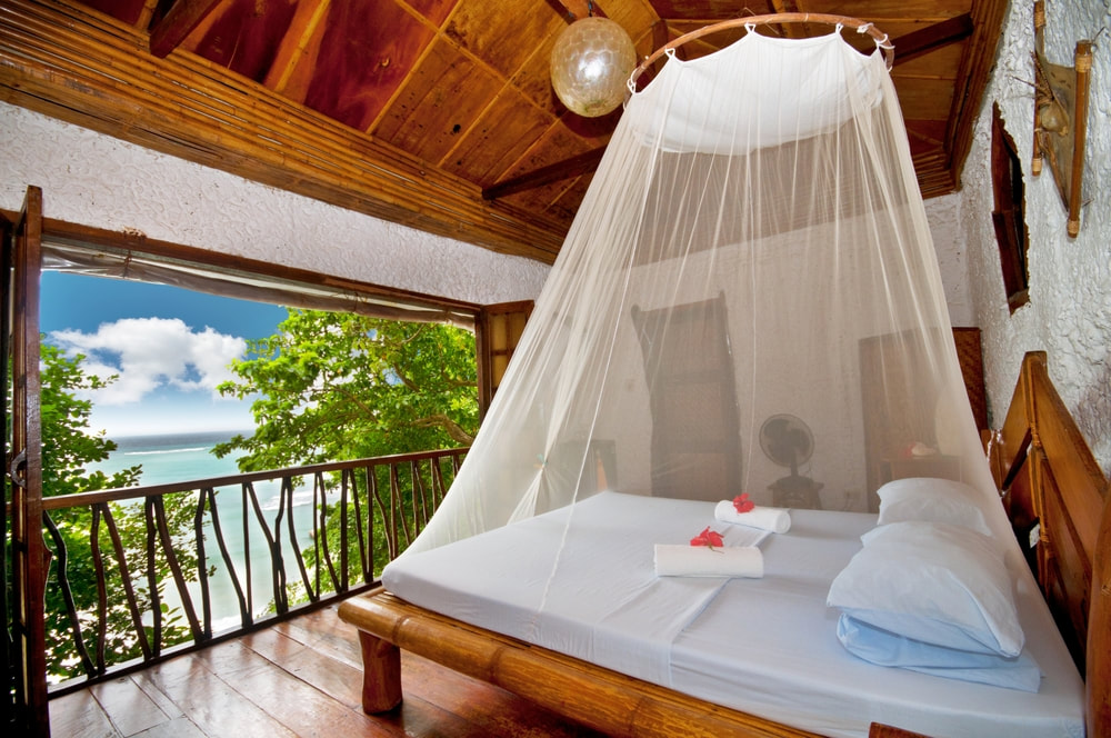 Bed and a view at a tropical hotel. 