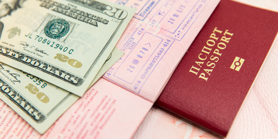 US currency and a Russian passport, juxtaposed, signifying international travel and financial exchange.