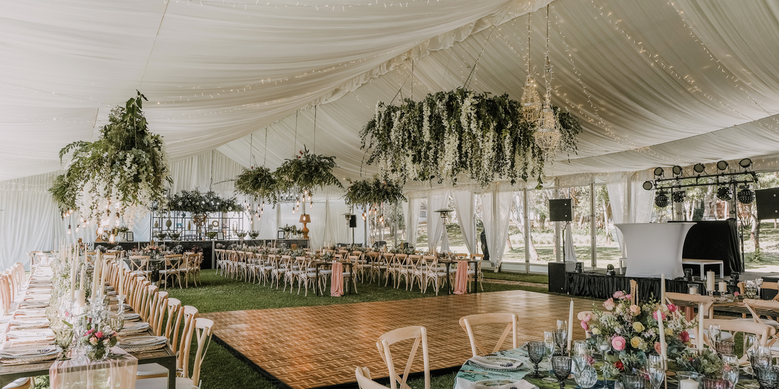 Elegant wedding reception space, complete with floral arrangements and wooden tables.