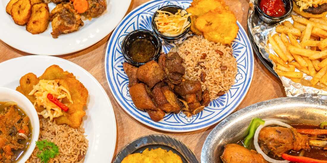 Traditional Haitian meal with griot fried pork rice beans fried plantains and pikliz served on a table