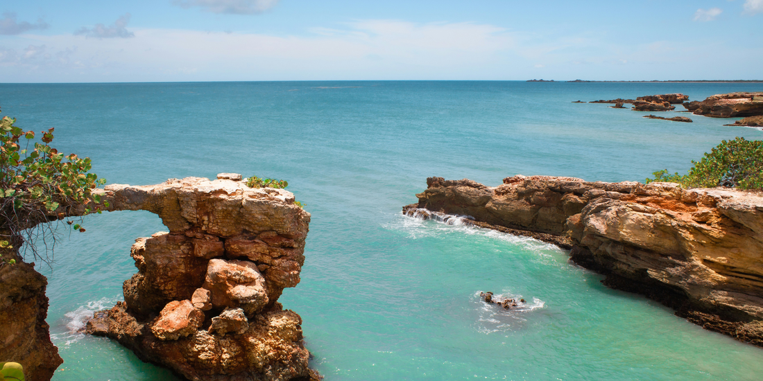 Natural rock arch along the coast of Puerto Rico with turquoise Caribbean water and rugged shoreline views