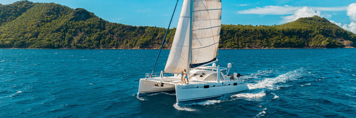 Luxury catamaran sailing through the turquoise waters of Saint Vincent and the Grenadines surrounded by lush Caribbean islands.