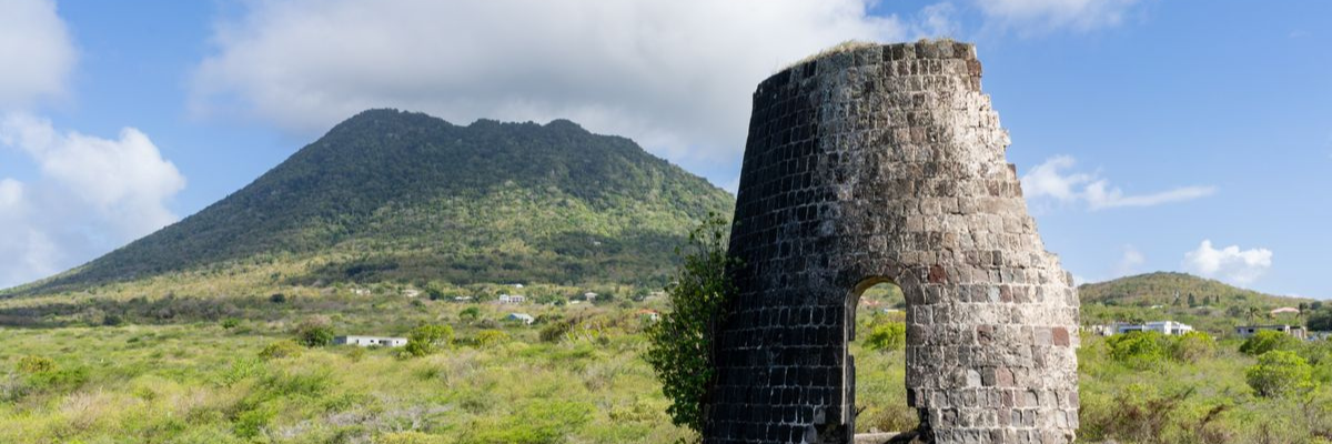 Historic stone sugar mill ruins with The Quill volcano in Sint Eustatius, Caribbean Netherlands.